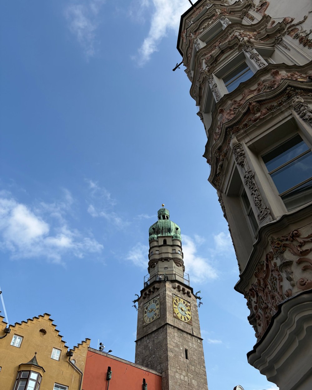 The Innsbruck city tower with its green dome against a blue sky