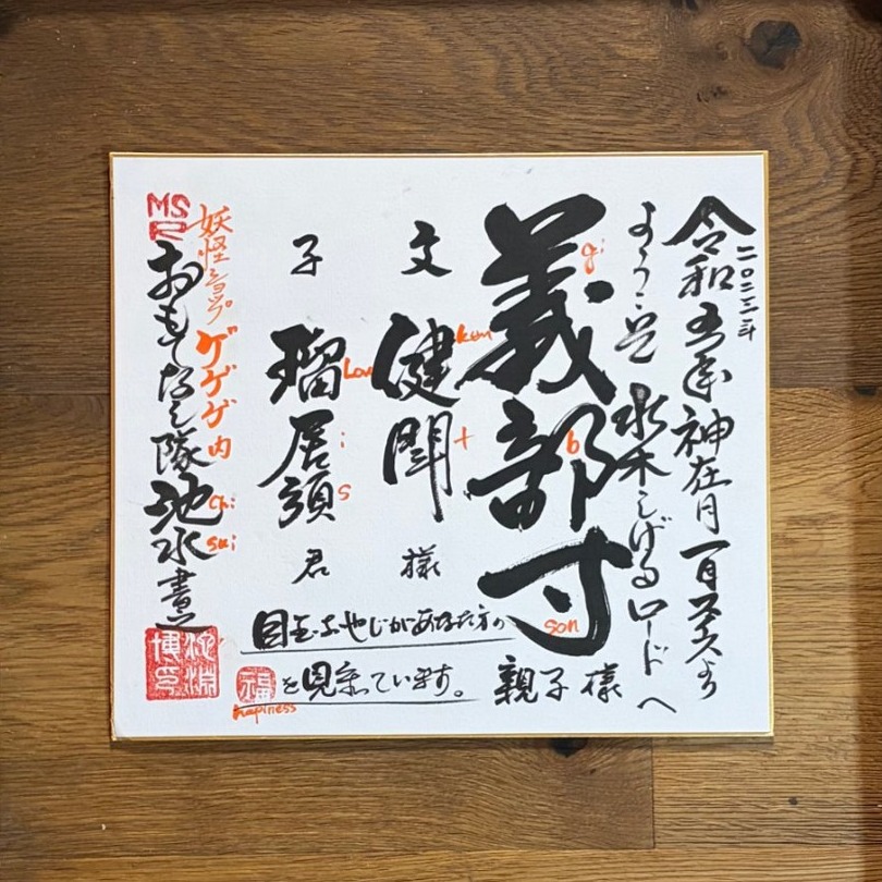 Japanese brush calligraphy in black ink with red seal stamps on a white board